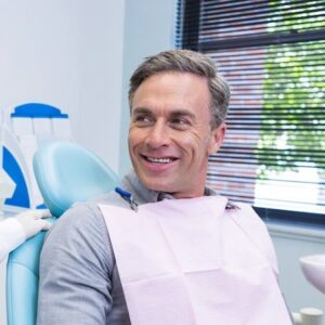 A man smiling before his dental examination at the dentists office